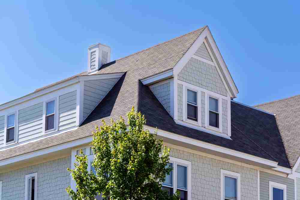Dormer,Windows,On,The,Sloped,Shingle,Roof,Of,A,Newly,built,home