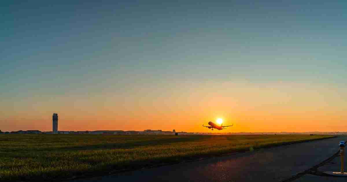 A plane taking off from John Glenn Columbus International Airport at sunset