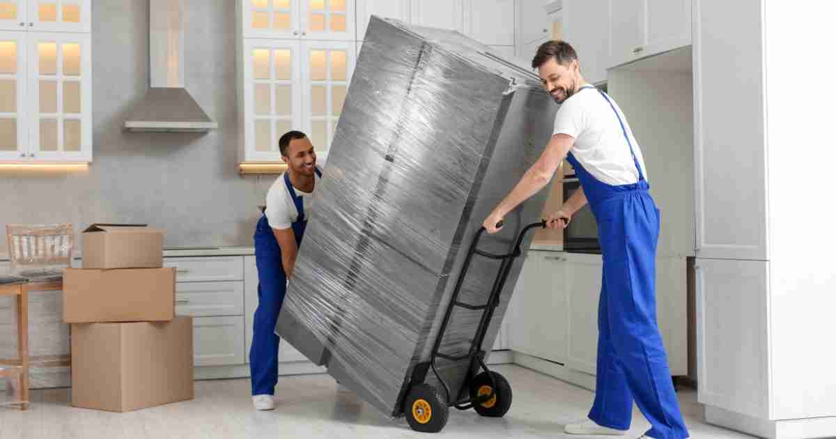 Fairborn OH movers carefully moving a fridge on a dolly. 