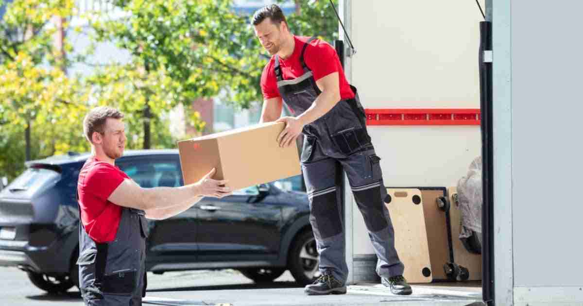 Two movers from a moving company in Obetz, OH carrying a box out of a truck 