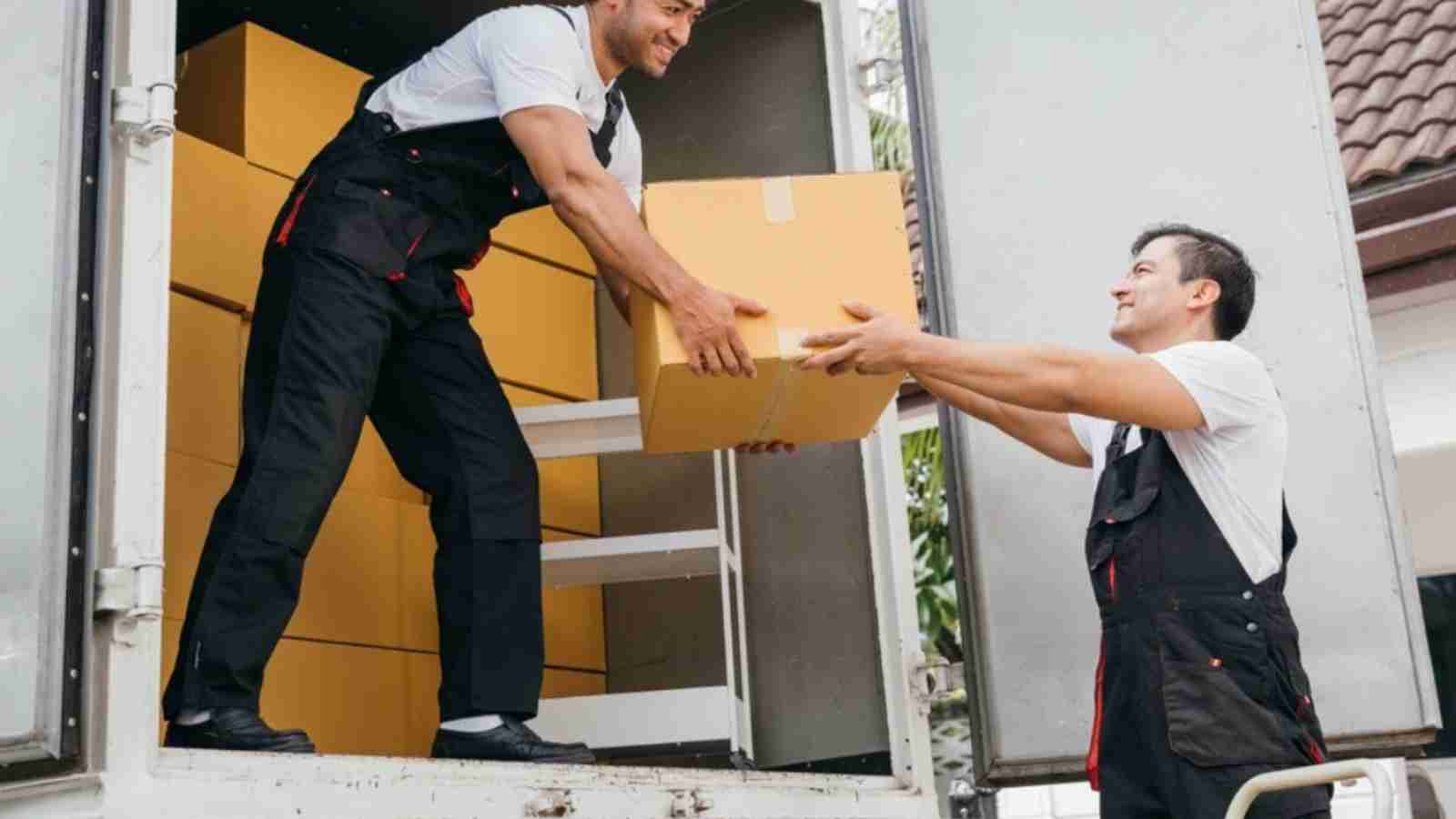 Two young movers in Whitehall unloading furniture from a moving truck.